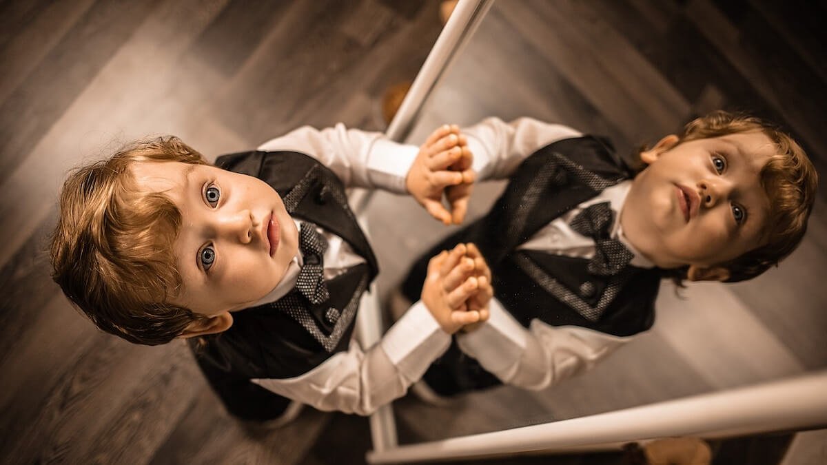 Menino com roupa social em frente ao espelho