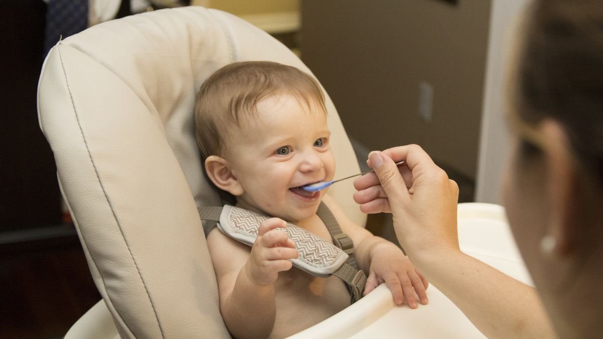 mae dando comida para o filho